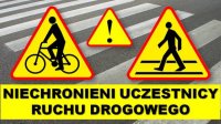 Napis &quot;Niechronieni Uczestnicy Ruchu Drogowego oraz 3 znaki ostrzegawcze: uwaga piesi, uwaga rowerzyści, uwaga inne niebezpieczeństwa. znaki na tle przejścia dla pieszych.