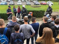 Na dworze policjanci prezentują młodzieży motocykle policyjne
