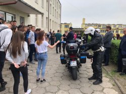 Policjanci stojący przy motocyklach opowiadają młodzieży o służbie na jednośladach
