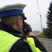 policjant ruchu drogowego namierzający prędkość pojazdów
