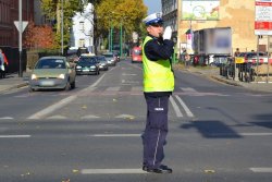 policjant stojący na skrzyżowaniu pokazujący &quot;jedź&quot;