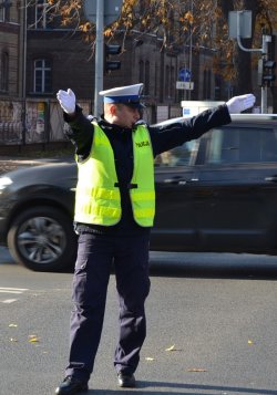 Policjant pokazujący światło zielone dla jadących z lewej strony policjanta (prosto i w lewo), dla innych kierunków zakaz jazdy