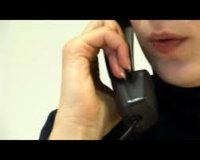 osoba trzymająca słuchawkę telefonu przy twarzy