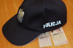 czapka policjanta pod którą znajdują się dwa blankiety prawa jazdy