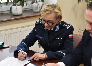 Na obrazku widzimy Zastępcę Komendanta Wojewódzkiego Policji w Poznaniu mł. insp. Violettę Mójta w trakcie podpisywania aktu darowizny.